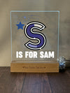 a glass block with the letter s is for sam