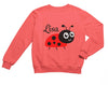 a pink sweatshirt with a lady bug on it