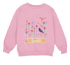 a pink sweater with a bird and flowers on it